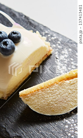 Elegant white chocolate mousse dome dessert topped with fresh blueberries and a floral petal Elegant white chocolate mousse dome dessert topped with fresh blueberries and a floral petal 137413481