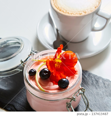 Luxury pink berry mousse served in an artisanal glass jar with fresh blueberries 137413487