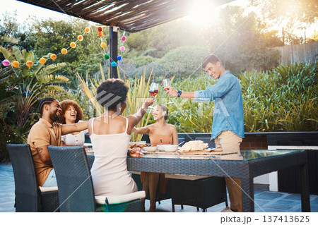 Toast, friends at dinner in garden at party and celebration with diversity, food and wine at outdoor party. Glass cheers, men and women at table, fun people with sunset drinks in backyard together. 137413625