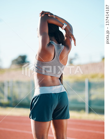 Stretching, sports and exercise with a woman outdoor on a track for running, training or workout. Behind African athlete person at stadium for arm stretch, fitness and muscle warm up or body wellness 137414187
