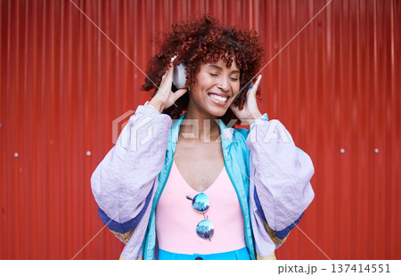 Music, dance and headphones with a retro woman on a red background in the city for energy or freedom. Radio, smile and streaming audio with a happy young afro person listening to sound for wellness Music, dance and headphones with a retro woman on a red background in the city for energy or freedom. Radio, smile and streaming audio with a happy young afro person listening to sound for wellness 137414551
