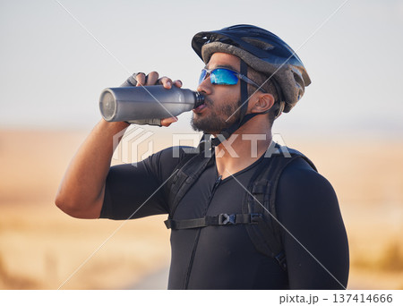 Fitness, health and man cyclist drinking water at race, marathon or competition training. Sports, workout and thirsty male athlete with hydration for wellness at an outdoor cardio exercise in nature. Fitness, health and man cyclist drinking water at race, marathon or competition training. Sports, workout and thirsty male athlete with hydration for wellness at an outdoor cardio exercise in nature. 137414666