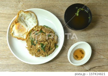 spicy fried mixed rice with slice pork basil topping egg in plate dipping chili fish sauce eat couple clear soup spicy fried mixed rice with slice pork basil topping egg in plate dipping chili fish sauce eat couple clear soup 137414821