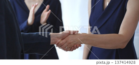 Business woman and businessman in blue jacket shaking hands, concluding a deal, and celebrating success with an agreement and partnership in a corporate office. Business people concept 137414928