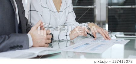 Business partners analyzing corporate data during a meeting, discussing financial reports and market trends. Business-people concept Business partners analyzing corporate data during a meeting, discussing financial reports and market trends. Business-people concept 137415078