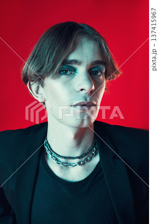 Fashion, portrait and gay man in makeup at studio isolated on a red background. Cosmetics, lgbtq style and face of model in cool clothes, punk aesthetic and serious person in Australia. 137415967