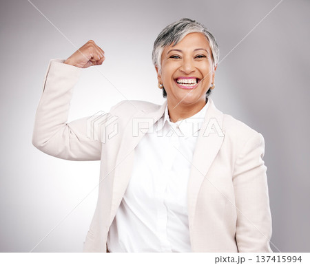 Strong, smile and portrait of businesswoman in a studio with strength or confidence gesture. Happy, excited and mature female model from Mexico flexing arm muscles for empowerment by gray background. 137415994
