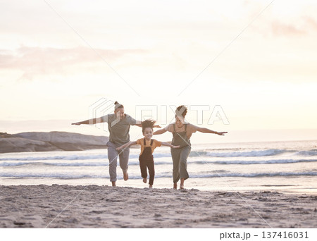 Happy, freedom and a family at the beach during sunset for flying, playing and bonding at the ocean. Smile, carefree and an interracial child, mother and father at the sea for a vacation or summer Happy, freedom and a family at the beach during sunset for flying, playing and bonding at the ocean. Smile, carefree and an interracial child, mother and father at the sea for a vacation or summer 137416031