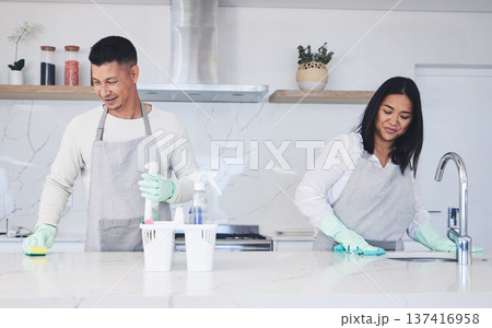 Happy couple, housekeeper and cleaning table in kitchen, chemical equipment or detergent in bacteria and germ removal at home. Man and woman wiping surface with cloth together in hygiene to sanitise 137416958