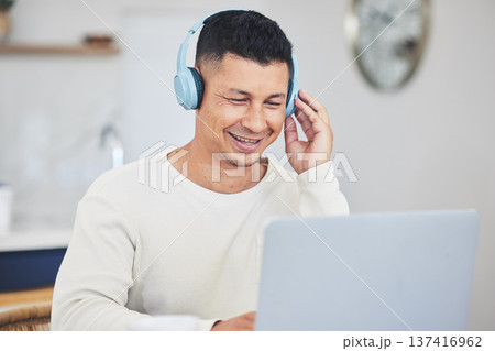 Remote work from home, smile and man with a laptop, headphones and typing with research for a project. Person, employee or copywriter with a pc, lounge or happiness with connection or search internet Remote work from home, smile and man with a laptop, headphones and typing with research for a project. Person, employee or copywriter with a pc, lounge or happiness with connection or search internet 137416962