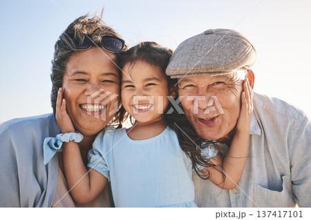 Smile, sky and portrait of a girl with her grandparents in nature on a family vacation or holiday. Happy, love and child holding her grandmother and grandfather with care on an outdoor weekend trip. Smile, sky and portrait of a girl with her grandparents in nature on a family vacation or holiday. Happy, love and child holding her grandmother and grandfather with care on an outdoor weekend trip. 137417101