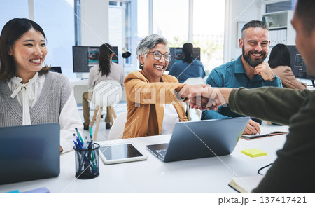 Creative people, fist bump and meeting in teamwork, success or achievement together at office. Group of employees touching hands in startup project, winning or team building promotion at workplace 137417421