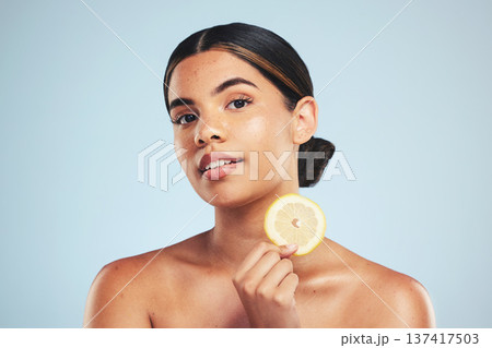 Portrait, woman and lemon in studio for skincare, wellness and organic cosmetics on grey background. Fruit, slice and face of model with citrus treatment for vitamin c, collagen and anti aging detox Portrait, woman and lemon in studio for skincare, wellness and organic cosmetics on grey background. Fruit, slice and face of model with citrus treatment for vitamin c, collagen and anti aging detox 137417503