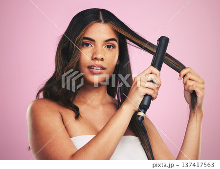 Portrait, woman and hair care with iron for studio beauty, cosmetic treatment or shine on pink background. Face of model, hairstyle or heating equipment of electric tools for smooth aesthetic texture Portrait, woman and hair care with iron for studio beauty, cosmetic treatment or shine on pink background. Face of model, hairstyle or heating equipment of electric tools for smooth aesthetic texture 137417563
