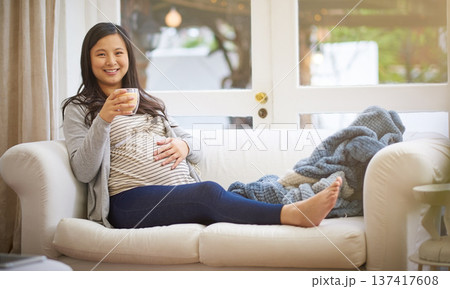 Portrait, pregnant woman and relax in home with coffee, peace and touch stomach on weekend break. Happy, female person and beverage in living room with pregnancy, rub belly and ready for motherhood. 137417608