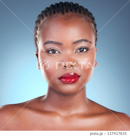 Portrait, beauty and black woman with makeup, cosmetics and dermatology on a blue studio background. Face, African person and model with red lips, gloss and glow with aesthetic, shine and skincare Portrait, beauty and black woman with makeup, cosmetics and dermatology on a blue studio background. Face, African person and model with red lips, gloss and glow with aesthetic, shine and skincare 137417635