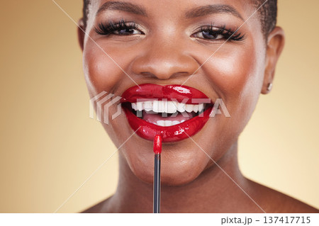 Makeup brush, beauty and a woman with red lipstick in studio for closeup, glow or cosmetics. Face of happy African person with facial shine, dermatology and application on mouth on a beige background Makeup brush, beauty and a woman with red lipstick in studio for closeup, glow or cosmetics. Face of happy African person with facial shine, dermatology and application on mouth on a beige background 137417715