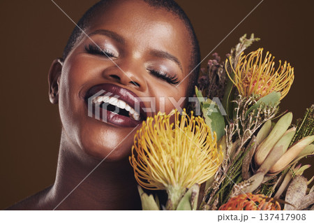 Skincare, nature and plant with the face of a black woman in studio on brown background for natural treatment. Beauty, protea or cosmetics and a young model for aesthetic wellness with flowers 137417908