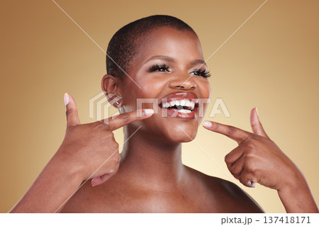 Teeth, beauty and a woman pointing at smile in studio for skin care, glow or cosmetics. Face of African model person with dental shine, dermatology and makeup announcement on a beige background 137418171