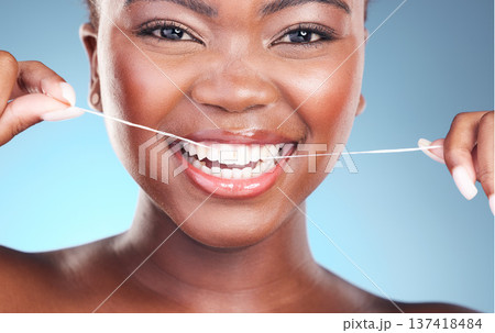 Happy woman, teeth and dental floss in cleaning, grooming or skincare against a blue studio background. Closeup of female person with big smile flossing in tooth whitening for oral, mouth or gum care Happy woman, teeth and dental floss in cleaning, grooming or skincare against a blue studio background. Closeup of female person with big smile flossing in tooth whitening for oral, mouth or gum care 137418484