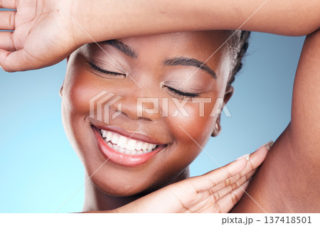 Beauty, skincare and black woman closeup of armpit and smile, cosmetics and makeup in studio. Wellness, happy African model on blue background and skin glow with shine from dermatology treatment Beauty, skincare and black woman closeup of armpit and smile, cosmetics and makeup in studio. Wellness, happy African model on blue background and skin glow with shine from dermatology treatment 137418501