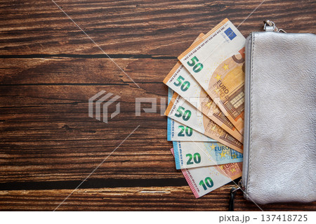 Leader silver partmone with paper euro money. Cash bills in the wallet for commerce concept on the wood background. Space for text. 137418725