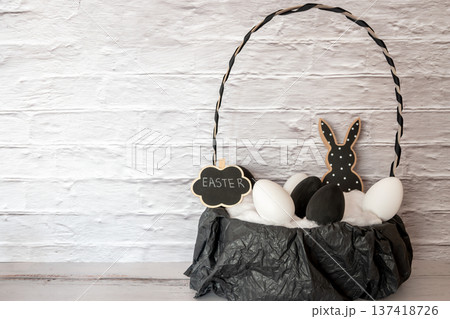 Black and white wood rabbit and eggs bouquet for easter celebration in the basket. Shopping of Easter holidays. Space for text. Black and white wood rabbit and eggs bouquet for easter celebration in the basket. Shopping of Easter holidays. Space for text. 137418726
