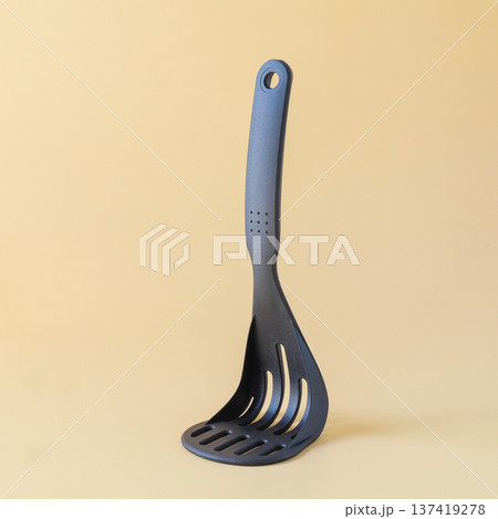 Black potato masher on background. Kitchenware. Pusher for mashed potatoes. 137419278