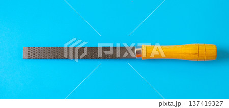 wood file tool for a carpenter craftsman who smoothes a piece of wood with a rasp. wood file tool for a carpenter craftsman who smoothes a piece of wood with a rasp. 137419327