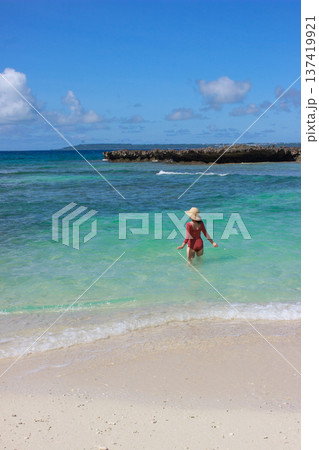 白い砂浜と透明な海へ歩いていく女性の風景 137419921
