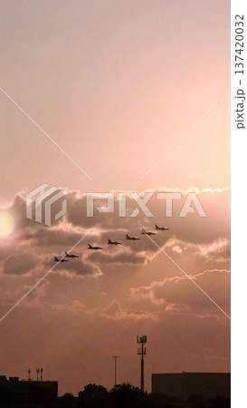 Jets Illuminate Evening. Aircraft Streak Across Fiery Sky. Sunset Fighters Create Vivid Aerial Display. Fast Jets Carve Through Glowing Clouds Casting Dramatic Silhouettes 137420032