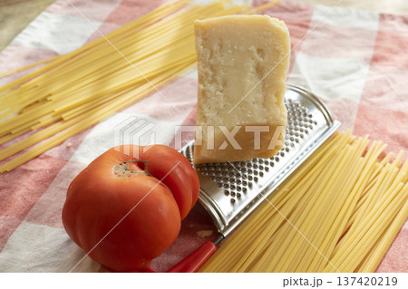 ingredients spaghetti to prepare with parmigiano, and a big tomato ingredients spaghetti to prepare with parmigiano, and a big tomato 137420219
