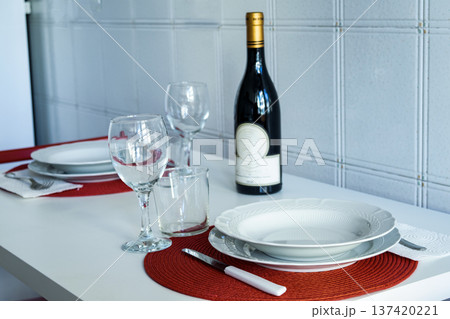 elegant dining table set for two with wine bottle and red placemats 137420221