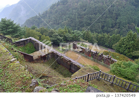 霧雨に煙る東洋のマチュピチュ 別子銅山東平地区の貯鉱庫跡と索道停車場跡全景 137420549