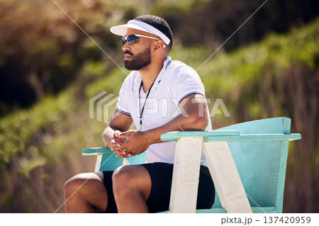 Summer, sports and a volleyball referee in a chair on the beach for authority, rules or regulations during a game. Health, professional or competition with a serious man refereeing a match in the day Summer, sports and a volleyball referee in a chair on the beach for authority, rules or regulations during a game. Health, professional or competition with a serious man refereeing a match in the day 137420959
