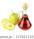 Glass Carafe of Red Vinegar with Fresh Green Apple Slices 137421110