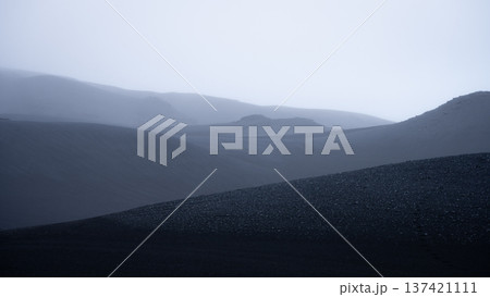 Hazy moonlike volcanic landscape with layers of black dunes disappearing in the distance, Iceland 137421111