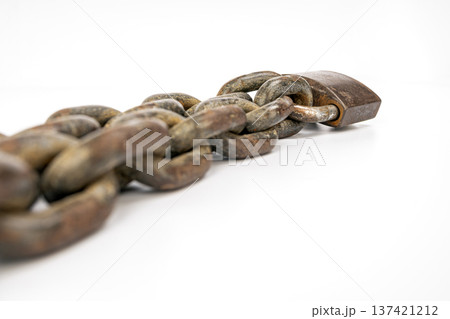 Close Up Photo of Heavy Rusty Metal Chain with Large Padlock Showing Wear and Weathering on a Pristine White Surface, Emphasizing Durability and Strength Close Up Photo of Heavy Rusty Metal Chain with Large Padlock Showing Wear and Weathering on a Pristine White Surface, Emphasizing Durability and Strength 137421212