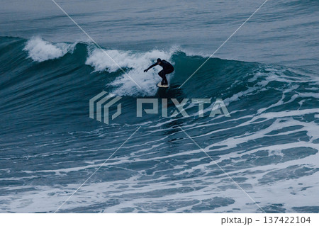 Surfer riding ocean wave in cold water, dark light 137422104