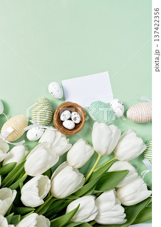 Elegant Easter flat lay with white tulips, decorative eggs and blank card template. Seasonal spring greeting design with pastel colors. Elegant Easter flat lay with white tulips, decorative eggs and blank card template. Seasonal spring greeting design with pastel colors. 137422356