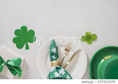 St Patrick table setting with shamrock decor and gold cutlery 137422479