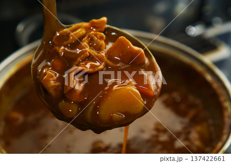 熱々の鍋からポークカレーをすくい上げる 137422661