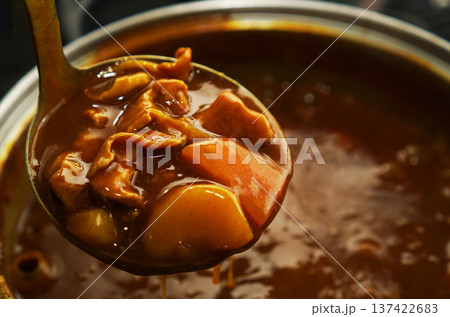 熱々の鍋からポークカレーをすくい上げる 137422683