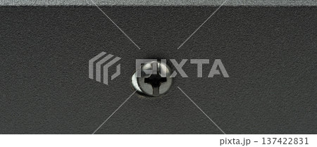Close-up view of a black screw in metal surface Close-up view of a black screw in metal surface 137422831