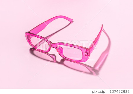 Stylish pink sunglasses with transparent glass on a white background Stylish pink sunglasses with transparent glass on a white background 137422922