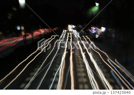 夜の道を走る車の光跡 137423040