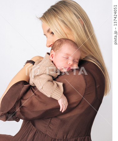 Woman holding her infant baby close to her chest. Warm moment of parenthood and baby care. Woman holding her infant baby close to her chest. Warm moment of parenthood and baby care. 137424051