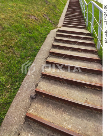 A staircase outdoors with a green field in the background. Journey and peaceful nature atmosphere. A staircase outdoors with a green field in the background. Journey and peaceful nature atmosphere. 137424300
