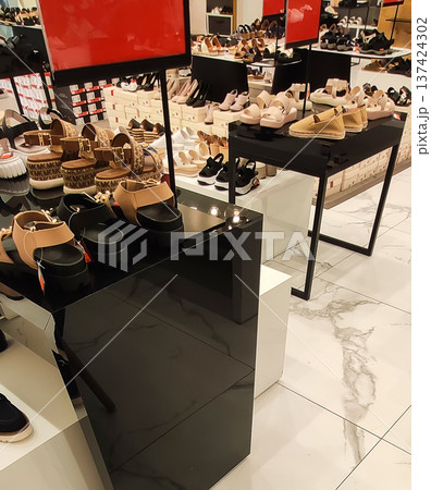 Shelves filled with casual and formal shoes in a retail shop. Stylish designs and contemporary shopping vibe. Shelves filled with casual and formal shoes in a retail shop. Stylish designs and contemporary shopping vibe. 137424302