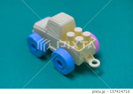 Colorful plastic toy truck on a vibrant teal background for kids playtime Colorful plastic toy truck on a vibrant teal background for kids playtime 137424718